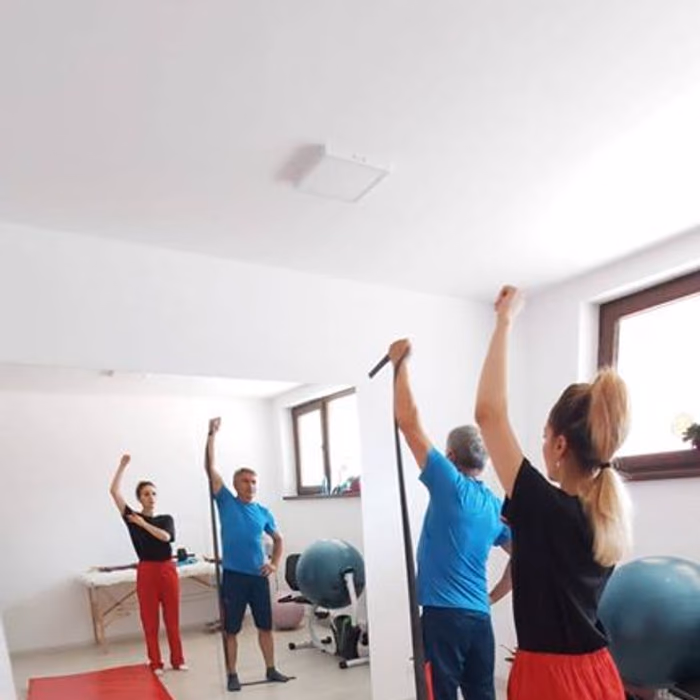 Kinetoterapeut ghidând un pacient la un exercițiu de stretching, la Fiziokineto Clinic